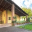 Giardino residence La Mason con portico, a lato un gazebo dove rilassarsi e accesso frontale al chiostro ed agli appartamenti